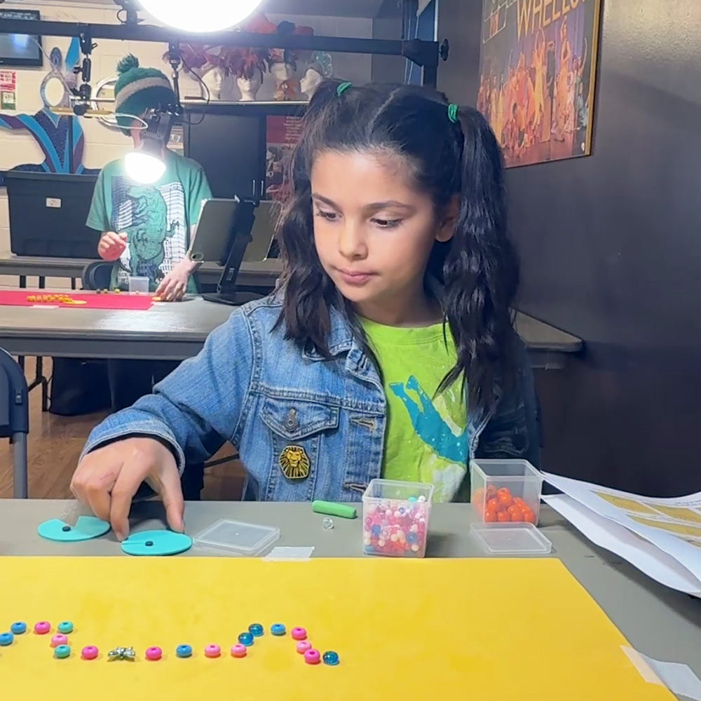 Two children animating a LEGO scene with a tablet in a Movie Makers class for ages 8 to 10