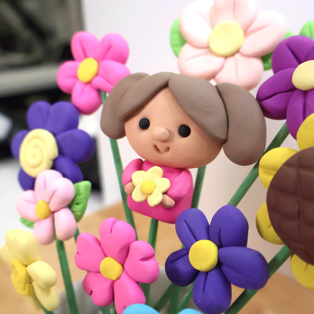 Close-up of a clay mini portrait among clay flowers